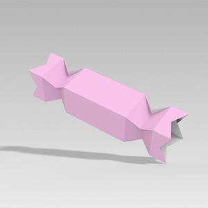 Peut inclure: Un emballage de bonbons en papier rose g&eacute;om&eacute;trique avec des extr&eacute;mit&eacute;s en forme d'&eacute;toile. L'emballage est d'un rose pastel clair et semble &ecirc;tre fait de papier pli&eacute;. L'emballage de bonbons est l&eacute;g&egrave;rement inclin&eacute;, projetant une ombre.