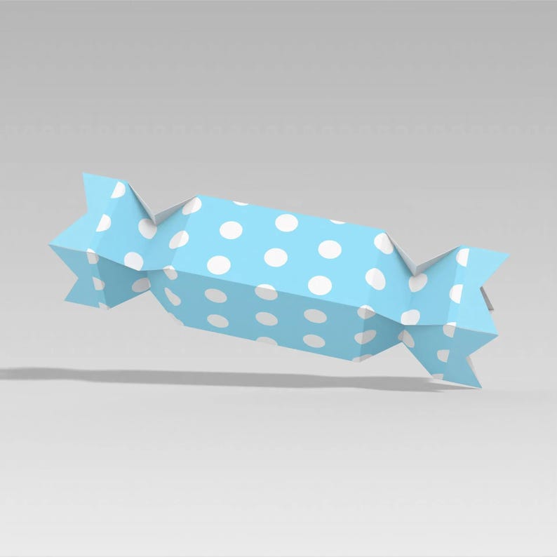 Peut inclure: Un emballage de bonbon bleu avec des pois blancs. L'emballage est pli&eacute; aux extr&eacute;mit&eacute;s et pr&eacute;sente un design g&eacute;om&eacute;trique. L'emballage de bonbon flotte dans les airs.