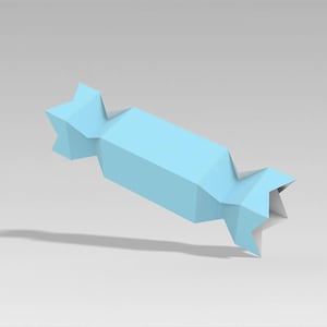 Peut inclure: Un emballage de bonbon en papier bleu clair de forme g&eacute;om&eacute;trique. L'emballage a un centre rectangulaire avec des extr&eacute;mit&eacute;s pointues, cr&eacute;ant une apparence stylis&eacute;e, semblable &agrave; un origami. L'objet projette une ombre sur une surface gris clair.