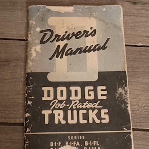 May include: A vintage paper Driver's Manual for Dodge Job-Rated Trucks. The cover is blue and black with a large letter D, featuring the text: Driver's Manual, DODGE Job-Rated TRUCKS, and Series B-I-F, B-I-FA, B-I-FL, B-I-H, B-I-HA.