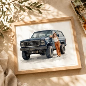 May include: Watercolor painting of a dark blue vintage SUV with large tires. The artwork is framed in a light wood frame. A person is leaning against the vehicle. The painting is on a white background.