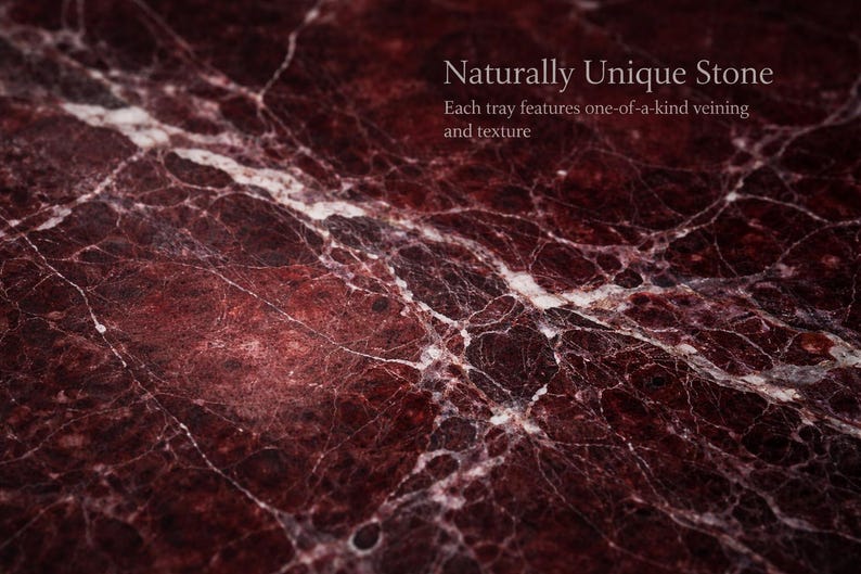 May include: Close-up of a richly textured stone surface. The stone is a deep burgundy colour with white veining throughout. The text "Naturally Unique Stone" and "Each tray features one-of-a-kind veining and texture" is visible.