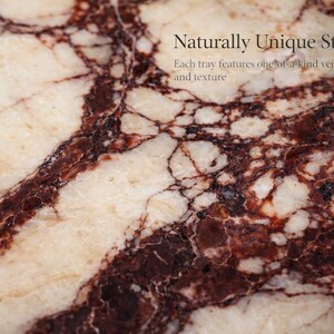 May include: Close-up of a stone surface with a unique pattern. The stone features a cream-coloured base with dark burgundy veining and the text "Naturally Unique Stone". Each tray features one-of-a-kind veining and texture.