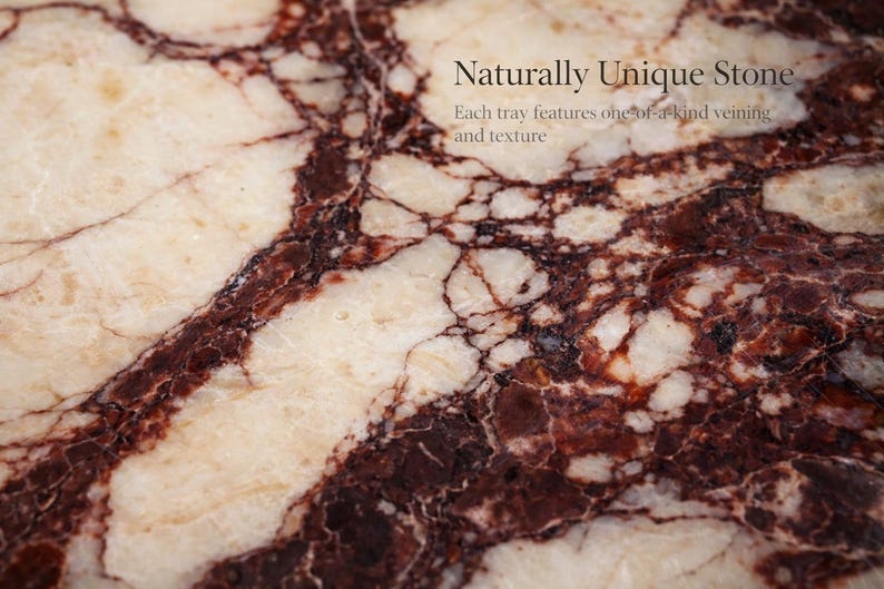 May include: Close-up of a stone surface with a unique pattern. The stone features a cream-coloured base with dark burgundy veining and the text "Naturally Unique Stone". Each tray features one-of-a-kind veining and texture.