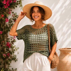 May include: A wide-brimmed straw hat, an olive green short-sleeved crochet top with a square grid pattern, a white camisole, white trousers, and a woven tan shoulder bag. The top features a loose, boxy fit with a round neckline and open weave.