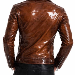 May include: A brown, glossy leather jacket with a classic biker style. The jacket features a notched collar, zipper details on the sleeves, and a tailored fit. The back view showcases the jacket's sleek design and polished finish.