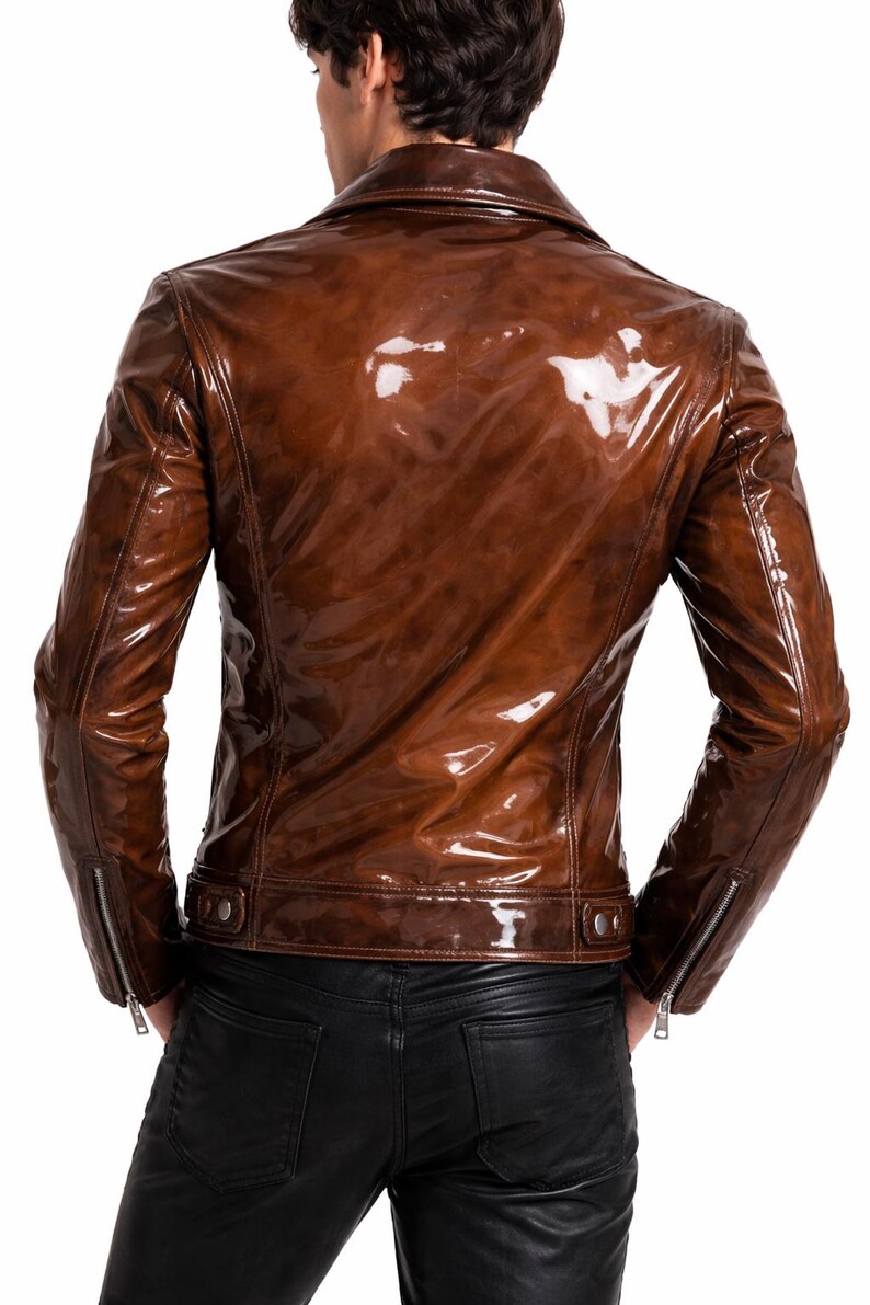 May include: A brown, glossy leather jacket with a classic biker style. The jacket features a notched collar, zipper details on the sleeves, and a tailored fit. The back view showcases the jacket's sleek design and polished finish.