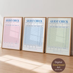 May include: Three framed wall art prints featuring a guest check design in pink, blue, and light green. Each print displays the text GUEST CHECK at the top, with columns for date, table, guests, server, and check number, plus rows for menu items.