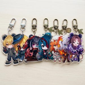 Könnte beinhalten: Eine Sammlung von Schlüsselanhängern mit Anime-Charakteren. Jeder Schlüsselanhänger zeigt ein einzigartiges Charakterdesign mit leuchtenden Farben und detaillierten Kunstwerken. Die Schlüsselanhänger haben Metallverschlüsse zur einfachen Befestigung.