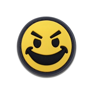 May include: A round, yellow patch with a black border featuring a mischievous smiley face. The face has black eyes and a curved, smiling mouth. The patch is a fun accessory.