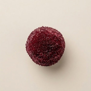 Peut inclure: Un objet sphérique avec une surface texturée d'un rouge bordeaux profond. L'extérieur présente un aspect dense, granuleux et bosselé qui recouvre toute la forme ronde, créant un profil visuel cohérent, rugueux et rouge foncé sur l'ensemble.