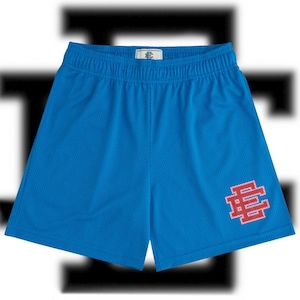 May include: Bright blue athletic shorts with an elastic waistband. The shorts feature a small logo on the front and a larger red and white logo on the lower right leg. The shorts are made of a breathable mesh material.