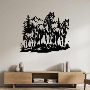 May include: Black metal wall art featuring three horses in a natural setting. The silhouette shows a mountain range, pine trees, and grassy ground, creating a rustic and artistic scene for home decor.