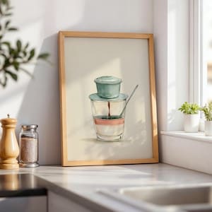 Może przedstawiać: Oprawiony wydruk artystyczny przedstawiający szczegółową ilustrację wietnamskiego filtra do kawy phin umieszczonego na przezroczystej szklance. Szklanka zawiera warstwy ciemnej kawy, różowy odcień i biel, ze srebrną łyżeczką wewnątrz.