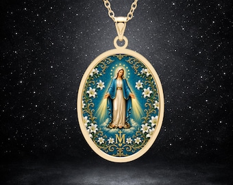 Puede incluir: Un collar con colgante ovalado de tono dorado que presenta una imagen central de la Virgen María con túnica azul y blanca, rodeada de lirios blancos y filigrana dorada sobre fondo azul, con un símbolo de M y cruz dorados en la base.