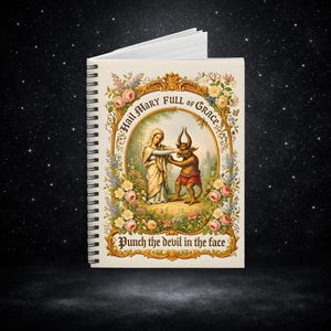 Könnte beinhalten: Spiralgebundenes Notizbuch mit einer Illustration im Vintage-Stil. Das Cover zeigt ein gerahmtes Bild einer Frau und eines Teufels, umgeben von floralen Elementen. Der Text enthält "Hail Mary Full of Grace" und "Punch the devil in the face."