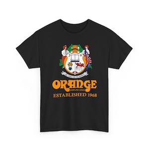Pode incluir: Camiseta preta com um design de brasão. O brasão apresenta a palavra "ORANGE" em laranja e o texto "AMPLIFICATION ESTABLISHED 1968". O brasão inclui um escudo com vários símbolos e figuras.