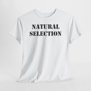 May include: A white t-shirt with the words "NATURAL SELECTION" printed in bold, black capital letters. The shirt has short sleeves and a crew neck. The fabric appears to be cotton.