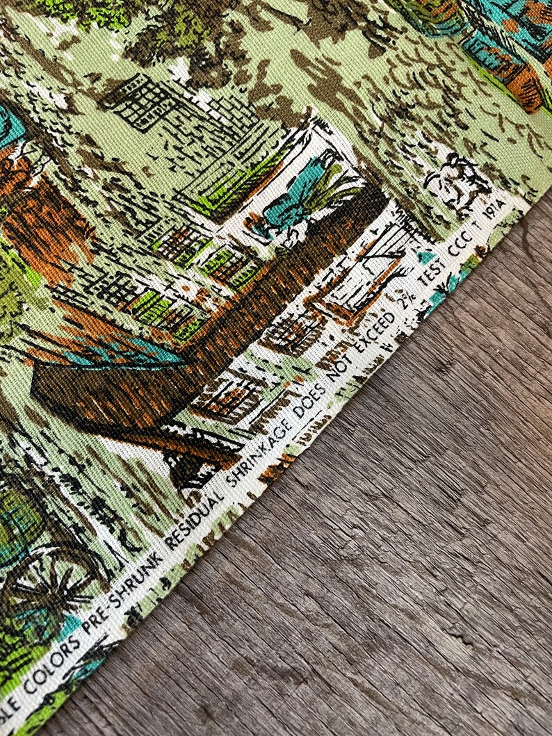 K&ouml;nnte beinhalten: Nahaufnahme eines Stoffes mit einem gr&uuml;n-braun-blauen Muster. Der Stoff hat ein Etikett mit der Aufschrift "LE COLORS PRE-SHRUNK RESIDUAL SHRINKAGE DOES NOT EXCEED 2% TEST CCCT 1914".