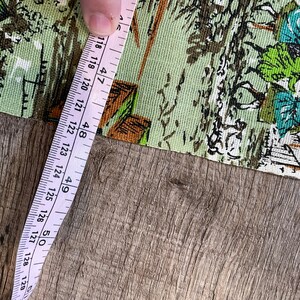 K&ouml;nnte beinhalten: Ein rosa Ma&szlig;band mit wei&szlig;en Markierungen liegt auf einer Holzoberfl&auml;che. Das Band misst 120 bis 128 cm.
