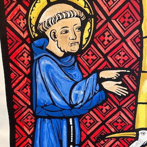 May include: A stained glass window depicting a saint in a blue robe with a halo. The saint is standing in front of a red and white geometric pattern. A white bird is partially visible in the lower right corner.