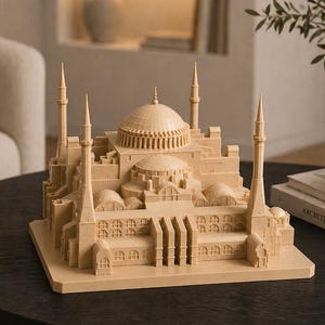 May include: A beige architectural model of a mosque with multiple minarets and a central dome. The model is placed on a dark round table, showcasing intricate details of the building's design. The model is a decorative item.