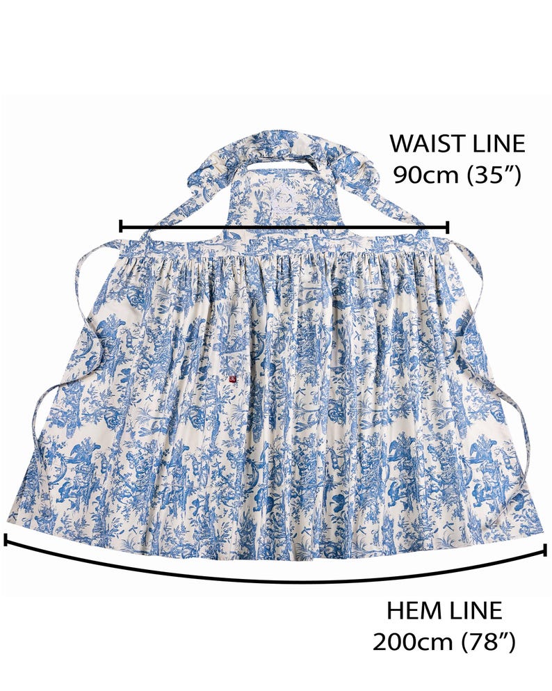 May include: A blue and white apron with a toile pattern. The apron has a waist line of 35 inches and a hem line of 78 inches. The apron has ties at the waist and neck. The apron is made of a lightweight fabric.