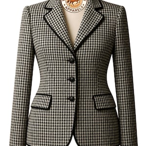 May include: A black and white houndstooth blazer featuring a notched lapel with black piping, three front buttons, and two flap pockets. A circular logo at the neckline displays a horse illustration and the text Western Glow Apparels.