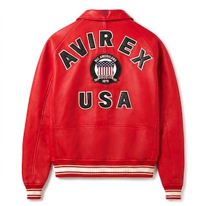 Puede incluir: Chaqueta de cuero roja con letras y parches blancos y negros. La parte trasera de la chaqueta presenta la palabra "AVIREX" arqueada en la parte superior, un parche circular con las palabras "ALL AMERICANS" y "USA" en la parte inferior.