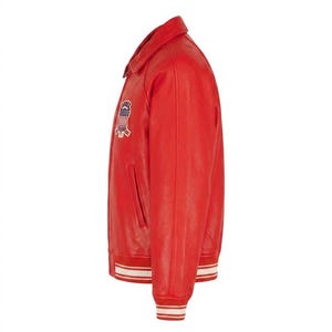 Puede incluir: Chaqueta de cuero roja con cuello cl&aacute;sico y parche en el pecho. La chaqueta presenta pu&ntilde;os y dobladillo a rayas blancas y rojas a juego. Tiene un bolsillo lateral y cierre de botones.