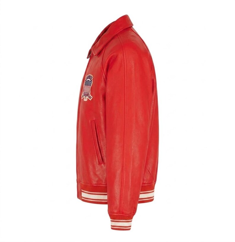 Puede incluir: Chaqueta de cuero roja con cuello cl&aacute;sico y parche en el pecho. La chaqueta presenta pu&ntilde;os y dobladillo a rayas blancas y rojas a juego. Tiene un bolsillo lateral y cierre de botones.