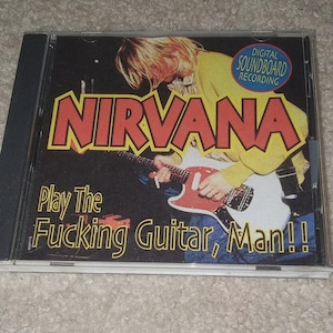 May include: A Nirvana CD case with the band's name in red and yellow lettering. The image features a person playing a red and white guitar, with the text "Play The Fucking Guitar, Man!!" below.