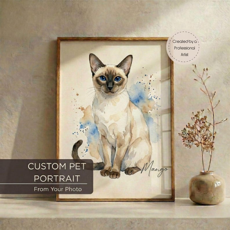 May include: Watercolor painting of a Siamese cat with blue eyes, set in a wooden frame. The artwork features blue and brown watercolor splashes. Text on the frame reads "CUSTOM PET PORTRAIT From Your Photo" and "Created by a Professional Artist."