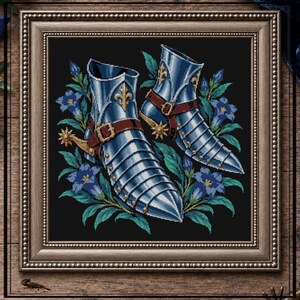 May include: A framed cross-stitch embroidery featuring a pair of metallic silver medieval sabatons with brown leather straps and gold spurs, surrounded by blue bell-shaped flowers and green leaves against a solid black background.