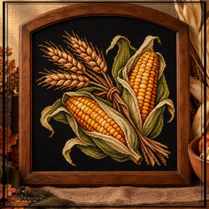 May include: A cross-stitch embroidery featuring two ears of yellow corn with green husks and a bundle of golden wheat stalks, all set against a solid black background and encased in a dark brown wooden frame with an arched top edge.