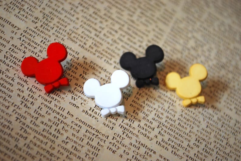 May include: Four wooden Mickey Mouse head ornaments in red, black, white, and yellow. Each ornament has a bow tie.