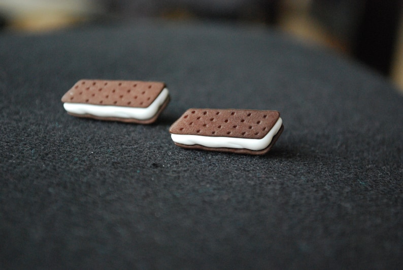 May include: Two small, brown and white, ice cream sandwich shaped earrings.