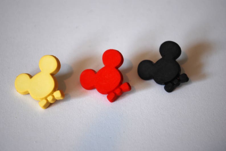 May include: Three wooden Mickey Mouse head ornaments in yellow, red, and black.