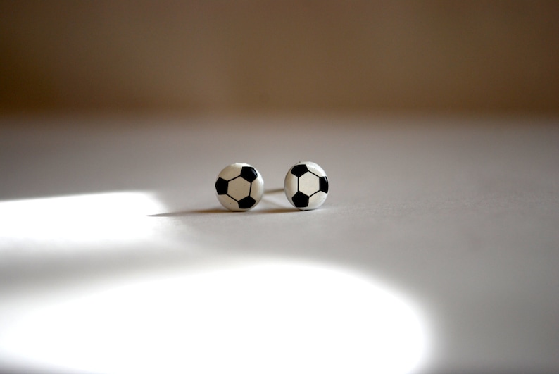 May include: A pair of silver stud earrings with a black and white soccer ball design.
