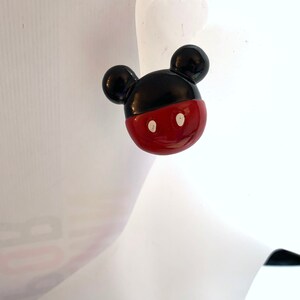 Op de afbeelding: Rode en zwarte Mickey Mouse oorbellen. De oorbellen zijn gemaakt van plastic en hebben een glanzende afwerking.