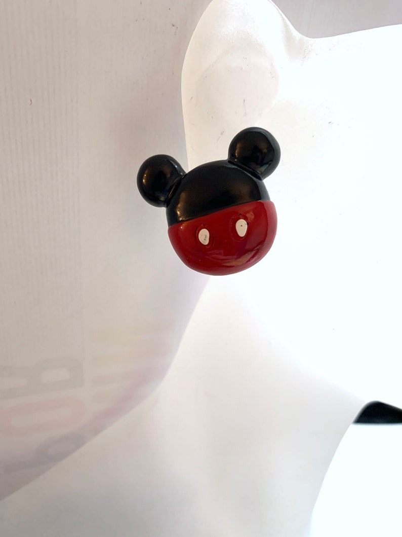Op de afbeelding: Rode en zwarte Mickey Mouse oorbellen. De oorbellen zijn gemaakt van plastic en hebben een glanzende afwerking.