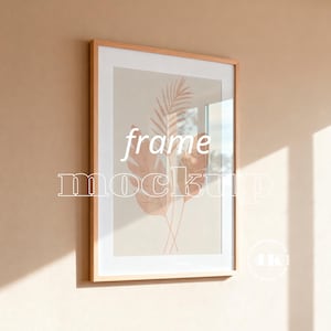Puede incluir: Una impresión artística enmarcada con un marco de madera clara. La obra de arte presenta una ilustración de estilo acuarela de hojas botánicas en tonos melocotón y beige. Las palabras "frame mockup" están superpuestas en la imagen.