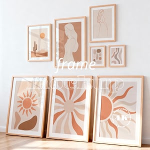 May include: A collection of framed art prints with a neutral color palette. The prints feature abstract designs, sunbursts, and line drawings of figures and landscapes. The frames are light wood.