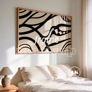 Puede incluir: Una pieza de arte mural rectangular en un marco de madera clara con un fondo beige y líneas curvas negras audaces junto a formas orgánicas. La obra muestra el texto blanco frame mockup en el centro de la impresión.