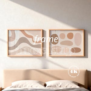 Könnte beinhalten: Zwei horizontale rechteckige Rahmen mit hellen Holzrändern, die abstrakte Kunstdrucke enthalten. Der linke Druck zeigt wellenförmige Linien in Beige- und Brauntönen. Der rechte Druck zeigt verschiedene solide ovale und kreisförmige Formen in ähnlichen Erdtönen.