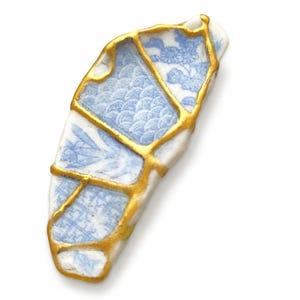 Reposapalillos estilo Kintsugi: Cerámica marina japonesa con detalles dorados.