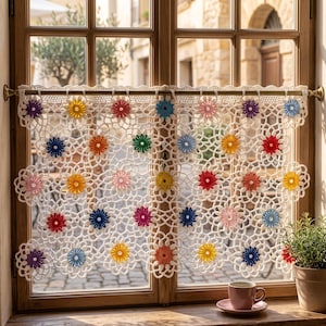 May include: A white crochet curtain featuring a repeating floral pattern with colourful centres in shades of yellow, red, blue, pink, orange, purple, and green. The curtain is suspended from a thin metal rod across a window frame.