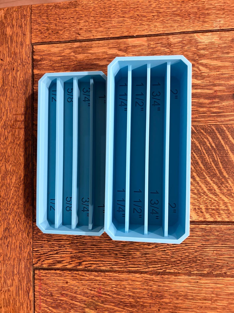 May include: Two light blue rectangular organizers with vertical dividers. The smaller organizer has measurements of 1/2", 5/8", 3/4", and 1". The larger organizer has measurements of 1 1/4", 1 1/2", 1 3/4", and 2".