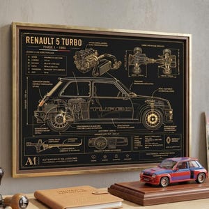 May include: A framed black and gold print of a Renault 5 Turbo car diagram. The print includes technical details and the text "RENAULT 5 TURBO PHASE 1 - 1980". A model car sits on a wooden base in front of the print.