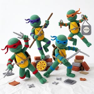May include: Four crocheted Teenage Mutant Ninja Turtles in action poses. Each turtle is green with a different coloured mask: red, purple, blue, and orange. They are holding weapons and a pizza slice. The turtles have yellow shells and are standing on a white surface.